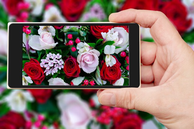 Blumen schöner Blumenstrauß auf dem Smartphone-Bildschirm. Dekorativer natürlicher Blumenhintergrund.