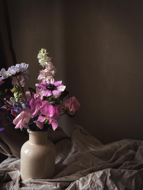 Blumen Stillleben Schöne bunte Blumen in Vase auf stimmungsvollem Hintergrund Stilvolle künstlerische Komposition aus Lathyrus Anemone Ranunculus Delphinium Erstaunliche florale vertikale Tapete