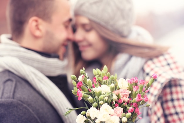 Blumen und küssendes Paar im Hintergrund