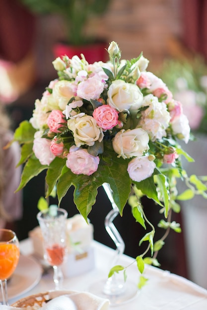 Blumenanordnung von frischen Rosen auf einem Banketttisch