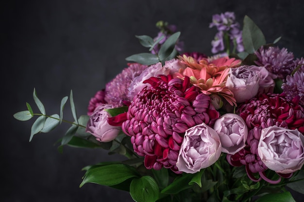 Blumenarrangement aus lila Chrysanthemen, Rosen und Eukalyptuszweigen