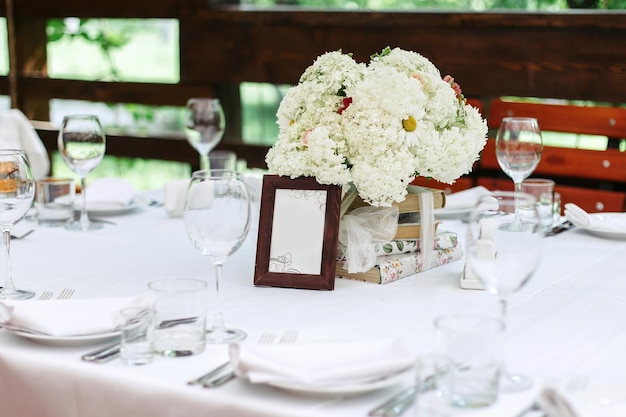 Blumenarrangement aus weißen Blumen am Hochzeitstisch