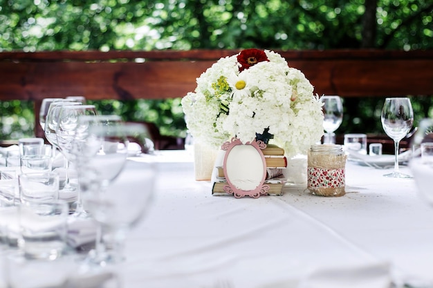 Blumenarrangement aus weißen Blumen am Hochzeitstisch