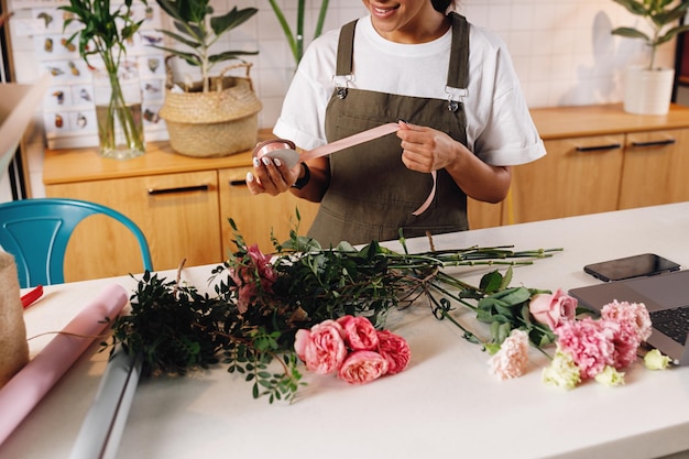 Foto blumenhändler machen einen blumenstrauß im laden