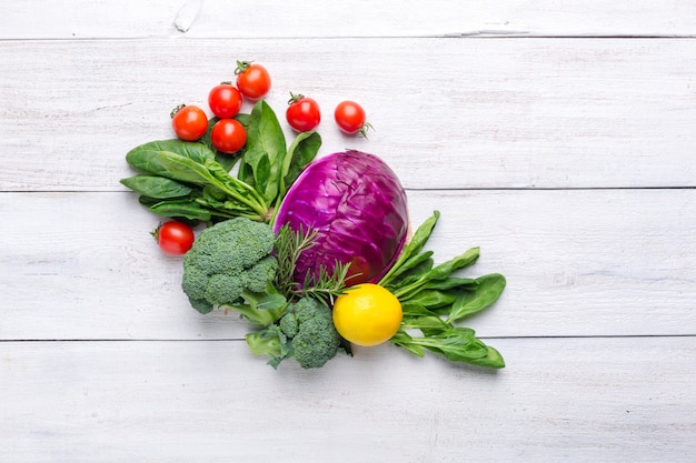 Blumenkohl, Brokkoli, Blauschimmelkohl, Zitrone und Kirschtomaten auf einem weißen hölzernen Hintergrund. Hintergrundmenü Essen