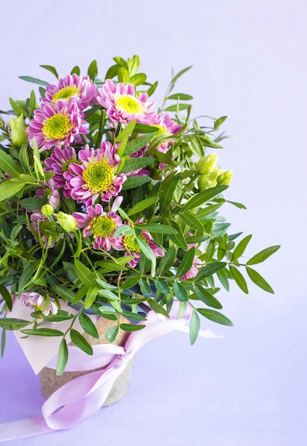 Blumenkomposition im Topf auf rosa pastellfarbenem Hintergrund Schöner Blumenstrauß aus Frühlingsblumen