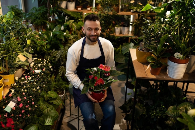 Blumenladenangestellter mit einem Blumentopf in seinen Händen