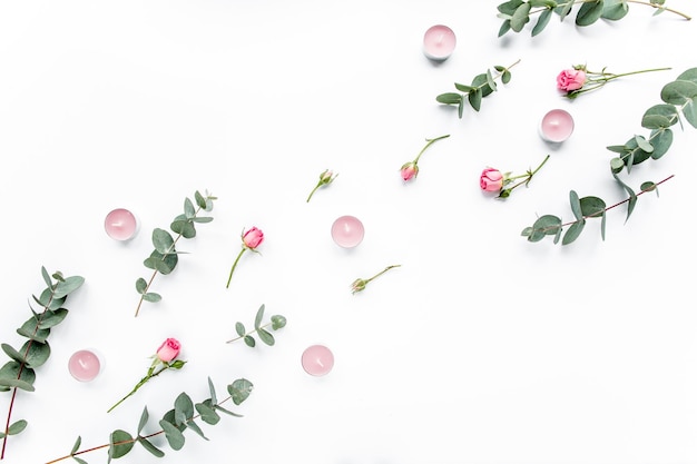 Blumenmuster aus rosa Rosen, grünen Blättern, Eukalyptuszweigen auf weißem Hintergrund, flache Lage, Draufsicht, Valentinstag-Hintergrund, Blumenmuster
