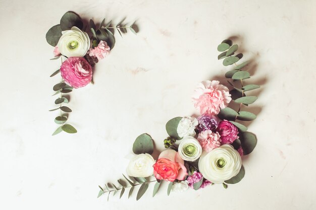 Foto blumenrunder rahmen mit eukalyptuszweigen und -blättern, flache blumen, draufsicht mit kopierraum