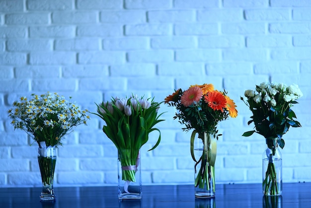 Blumensträuße in Vasen auf dem Tisch Frühling