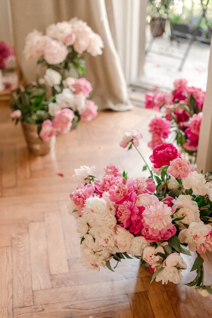 Blumensträuße von Pfingstrosen nahe Fenster