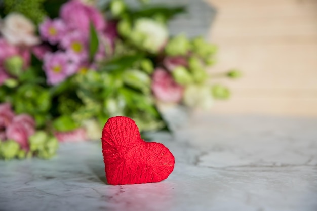 Blumenstrauß aus frischen burgunderfarbenen Rosen und festlichen Herzen auf Marmorhintergrund Duftende Blumen Geschenkkonzept für Valentinstag, Hochzeit oder Geburtstag flach lag Kopie Raum selektiven Fokus