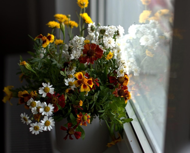 Blumenstrauß aus hellen Herbstblumen auf dem Fenster verschwommener Hintergrund, selektiver Fokus