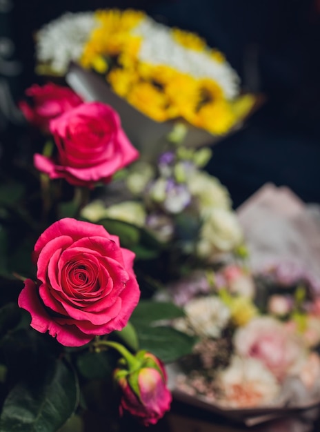 Blumenstrauß aus kleinen rosa Rosen am Holztisch