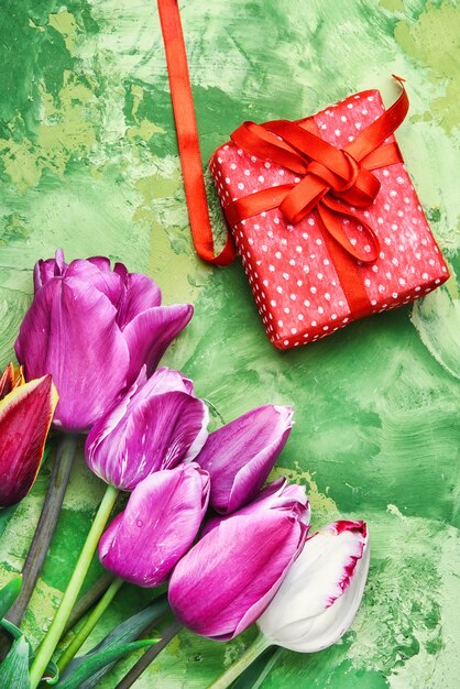 Blumenstrauß aus lila Tulpen und Geschenkbox