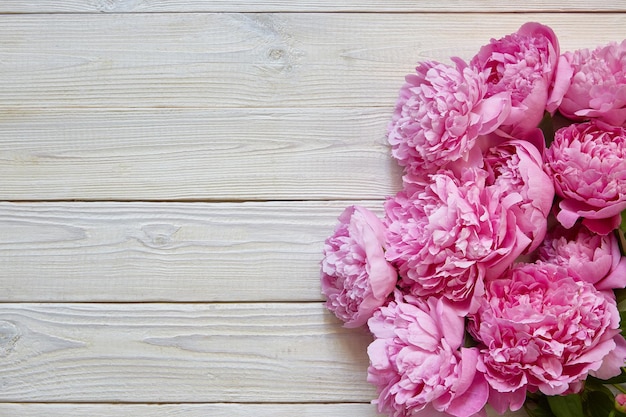 Blumenstrauß aus Pfingstrosen auf weißem Holzhintergrund mit Kopierraum. Ein Ort für einen Text über Valentinstag, Muttertag, Geburtstag.