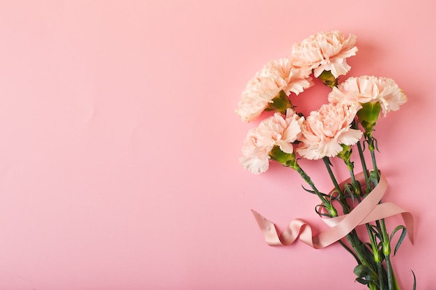 Blumenstrauß aus rosa Nelkenstrauß auf rosa Tischhintergrund