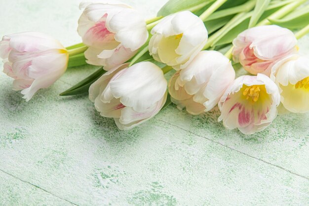 Blumenstrauß aus rosa Tulpen auf grünem Holzhintergrund Frühlingsferien Hintergrund Platz für Text Flach lag