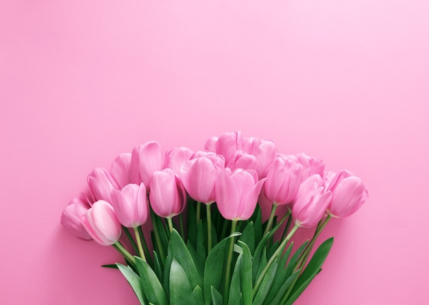Blumenstrauß aus rosa Tulpen auf rosa HintergrundFlacher Platz für Text-Draufsicht kopieren