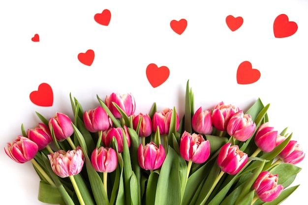 Blumenstrauß aus rosa Tulpen mit Herzen auf weißem Hintergrund Valentinstag Kopieren Sie Platz für Text