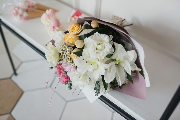 Blumenstrauß aus weißen Blumen auf einem Holzregal, Ansicht von oben