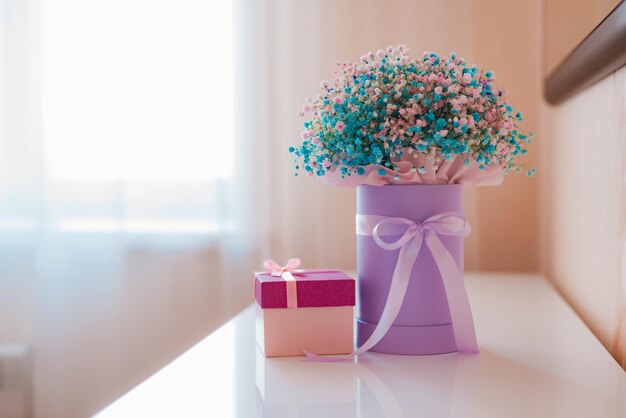 Blumenstrauß aus wunderschönen bunten Gypsophila-Blumen in einer Geschenkbox auf dem Schminktisch auf hellem Hintergrund Internationaler Frauentag 8. März Valentinstag Muttertag