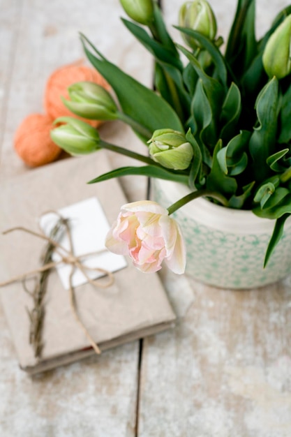 Blumenstrauß aus zarten rosa Tulpen auf einem hölzernen Hintergrund