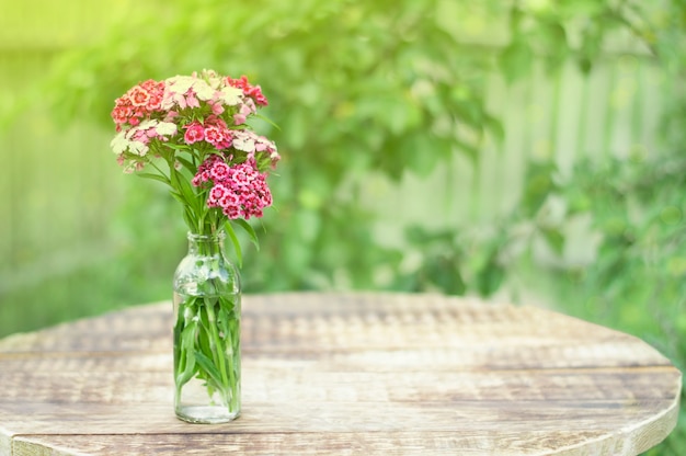 Foto blumenstrauß blumen in bank auf tisch im sonnenlicht