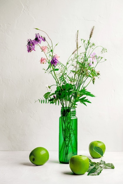 Blumenstrauß der Feldblumen in der grünen Vase