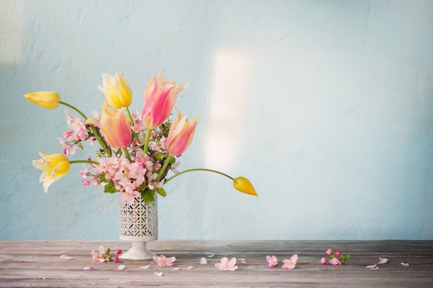 Blumenstrauß der frühlingsblumen an der blauen wand