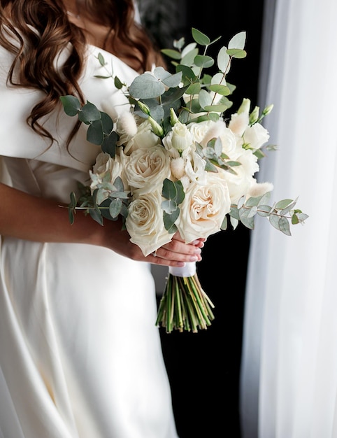 Blumenstrauß in den Händen der Brautfrau, die sich vor der Hochzeitszeremonie fertig macht