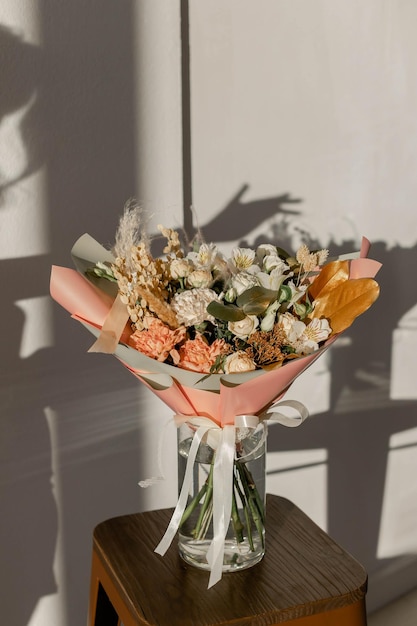 Blumenstrauß in goldenen Farbtönen in der Sonne Nelke Rose Alstroemeria Trockenblumen