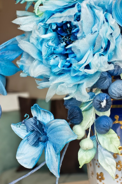 Blumenstrauß mit blauen großen Blüten und geschlossenen Knospen. Künstliche Blumen in einer Vase für den Innenraum