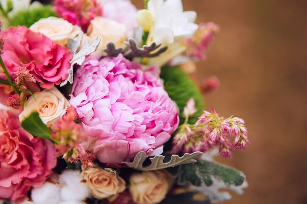 Blumenstrauß mit Rosen, Pfingstrosen, Nelken. zartes Bouquet in rosa Farben. Eukalyptusblätter.