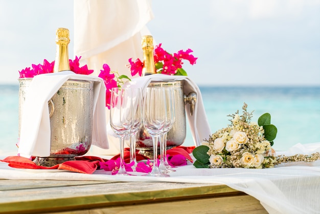 Blumenstrauß und Glas und Champagner im Hochzeitsbogen