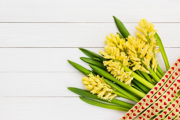 Blumenstrauß von gelben Hyazinthen auf weißem hölzernem Hintergrund.