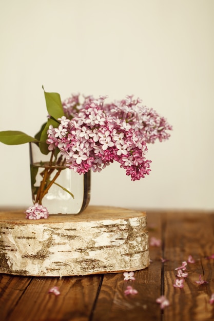 Blumenstrauß von lila Frühlingsblumen auf hölzernem Hintergrund.