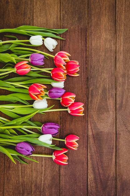 Blumenstrauß von schönen farbigen Blumen auf hölzernem Schreibtisch