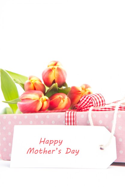 Blumenstrauß von Tulpen auf einem Geschenk mit einer glücklichen Mutterkarte