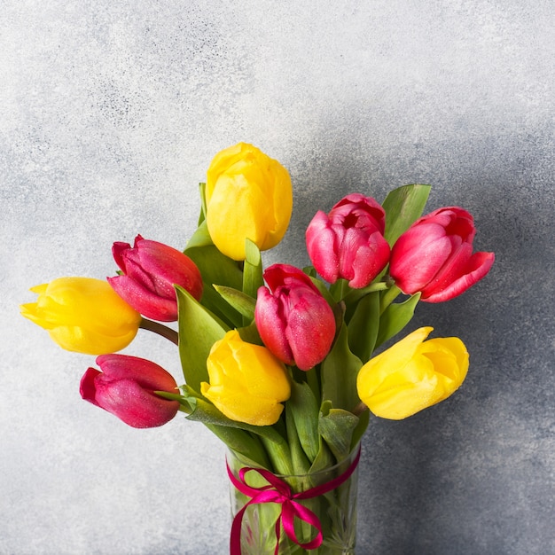 Blumenstrauß von Tulpen gelb und rosa auf einem Grau.