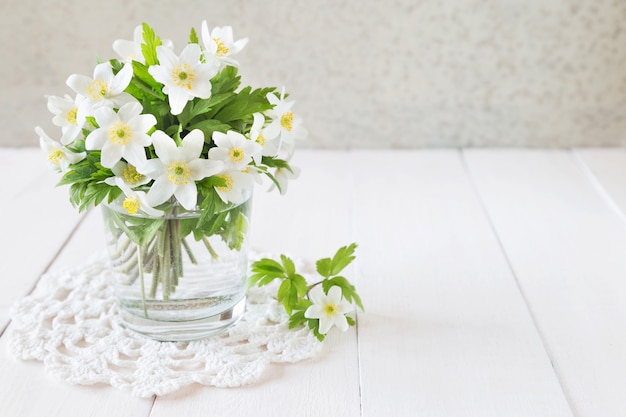 Blumenstrauß von weißen Frühlingsblumen in einem Glas