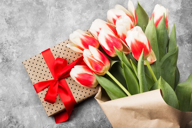 Blumenstrauß von weißen rosa Tulpen auf einem grauen Hintergrund. Ansicht von oben