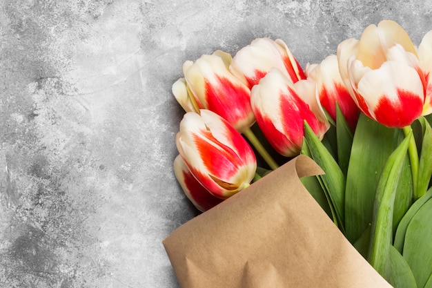 Blumenstrauß von weißen rosa Tulpen auf einem grauen Hintergrund. Draufsicht, Kopie, Raum