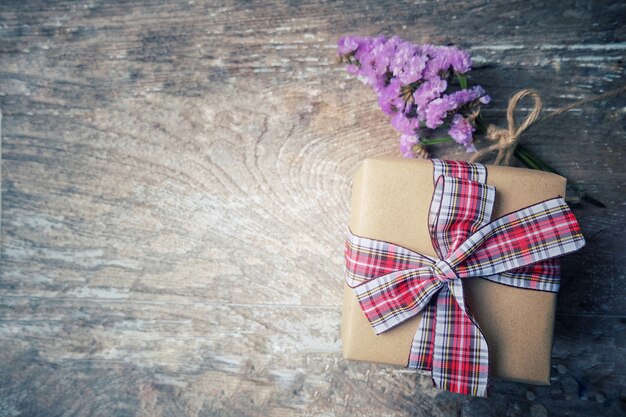 Foto blumenstraußblumen und -geschenkbox auf weinlese und altem holztisch.