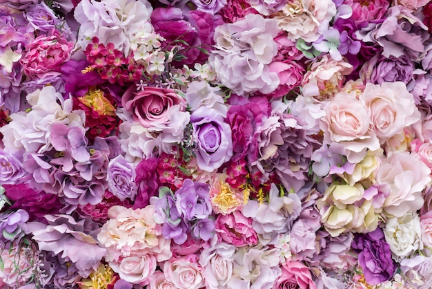 Blumentexturhintergrund für Hochzeitsszene. Rosen, Pfingstrosen und Hortensien, künstliche Blumen an der Wand.