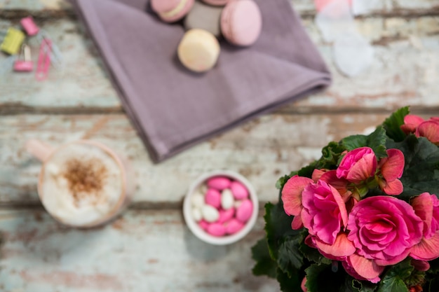 Blumenvase, Makronen und eine Tasse Kaffee