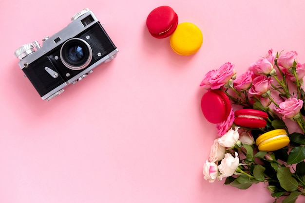 Blumenzusammensetzung mit einem Kranz von rosa Rosen und von Retro- Kamera auf Rosa. Valentinstag