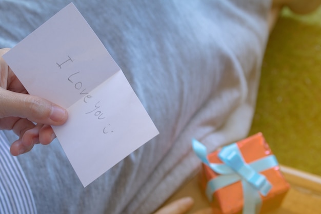 Blurred of Asian woman is reading valentine&#39;s card with gift box