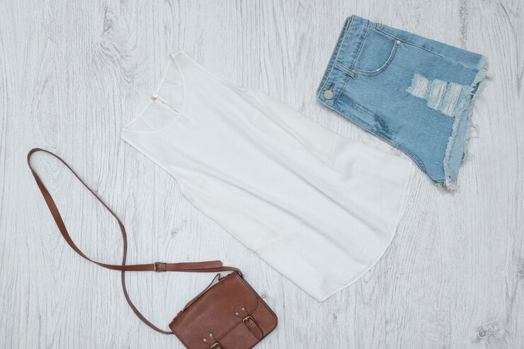 Foto blusa branca, bolsa e shorts jeans rasgados. conceito elegante