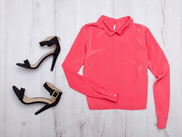 Blusa coral y zapatos negros.